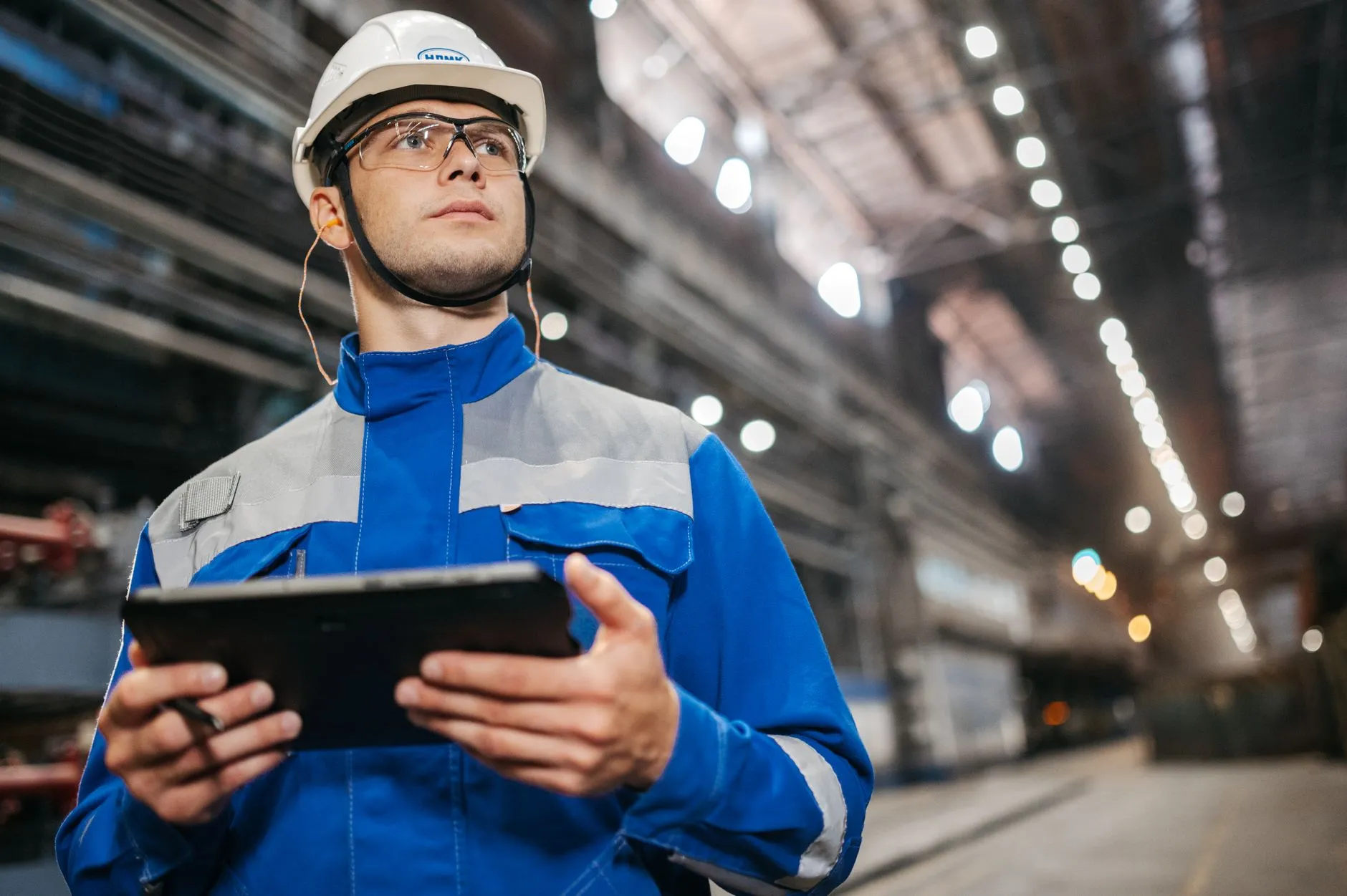 Ingenieur erfasst mit einem Tablet Produktionsdaten in einer Werkshalle